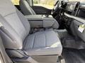 Interior view of a 2024 Ford F-550 showing gray upholstered front seats and a central console with storage space