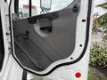 Interior door panel of a 2005 Freightliner M2 106 featuring a gray finish with a handle and controls for window and mirror adjustment