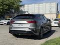 A silver 2024 Kia Forte5 viewed from the rear with sleek lines and dual exhausts showcasing its sporty design