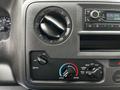 Dashboard controls of a 2021 Ford E-450 featuring climate control dials and a car radio display