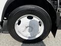 Close-up of a white wheel and tire from a 2016 Isuzu NQR showing the rim design and tread pattern