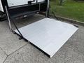 A silver loading ramp extended from the back of a vehicle designed for accessibility and transporting equipment or individuals