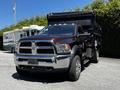 A 2015 RAM 5500 truck with a brown body and black dump bed is parked, featuring a shiny front grille and round headlights
