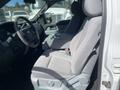 A gray cloth seat of a 2012 Ford F-150 with armrest and seatbelt visible, set in the driver's side area of the vehicle
