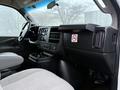 Interior view of a 2016 GMC Savana showing the dashboard seats and center console with controls and storage compartments