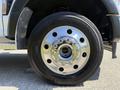 Close-up of a chrome wheel rim on a 2023 Ford F-550 featuring a black tire with detailed tread pattern and prominent lug nuts