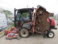 A 2013 Toro Grounds Master 5910 with a cabin and three large mower decks positioned at an angle showing its cutting blades and wheels