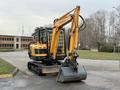 2022 Hyundai R55-9A excavator with a yellow arm and bucket positioned for digging on a construction site