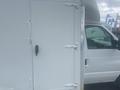 A 2004 Ford Econoline with a white exterior and a side door featuring metal hinges and a black handle
