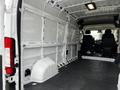 A 2021 RAM Promaster van interior featuring empty cargo space with metal framing and two black seats in the front area