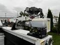 A 2015 Ford F-550 service truck equipped with a utility crane mounted on the bed featuring a winch and hydraulic controls