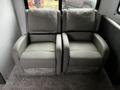 Two gray recliner chairs with a contemporary design featuring the name "Thomas Payne" on the front upholstery