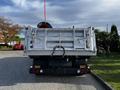 A 2011 International 7500 truck with a silver dump bed and a black snow plow attached to the front