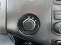 A black four-wheel drive control knob with settings for 2H 4H and 4L on a dashboard surface of a 2011 Ford F-450 SD
