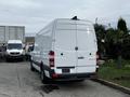 A white 2016 Mercedes-Benz Sprinter van with a high roof and rear doors is parked, showing its sleek design and cargo space