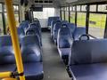 A 2018 Chevrolet Express interior with rows of blue seating and a bright spacious layout