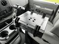 A RAM Tough Tray mounted in the cab of a 2009 Ford Econoline with adjustable clamps and openings for device storage and organization