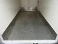 A clean metal diamond plate floor of a 2020 Ford Transit cargo area with no visible items inside