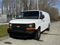 White 2015 Chevrolet Express van with black front grille parked on a paved surface