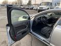 A silver 2006 Audi A6 with the driver's door open showing a leather interior and dashboard with various controls