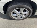 A close-up of a silver alloy wheel with a five-spoke design on a 2005 Chrysler PT Cruiser tire