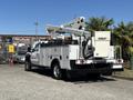 A 2016 Ford F-550 truck with a utility body and a Versalift aerial lift mounted on the rear