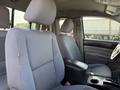 Interior of a 2015 Toyota Tacoma showing the front seats and center console with a fabric finish on the seats and a dark console area