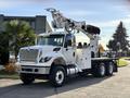 A white 2011 International 7500 truck with a hydraulic crane mounted on the rear and a utility bed equipped with various tools and compartments