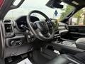 Interior of a 2024 RAM 3500 with a steering wheel and a large touchscreen display on the dashboard showing modern controls and leather seating