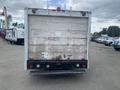 A 2004 Ford Econoline van viewed from the rear showing a dirty exterior with visible wear and tear and a step bumper