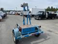 A blue 2003 U-Built Reel Trailer with a raised frame and equipment mounted on top including a large light and control box