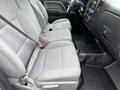 Interior view of a 2015 GMC Sierra 1500 showing two front seats with gray fabric upholstery and seatbelts visible