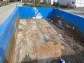 A 2009 Dodge Ram 5500 truck bed with a blue interior covered in dirt debris and some visible rust