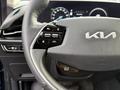 Steering wheel of a 2023 Kia Niro EV featuring control buttons for driving modes and safety features