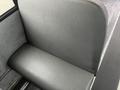 A black vinyl seat from a 2007 Freightliner B2 bus with a textured surface and a smooth seat cushion