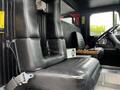Interior of a 1991 Sutphen Deluge featuring black leather seats with armrests and a steering wheel visible in the foreground