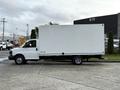 A white 2015 GMC Savana box truck with a flatbed and a large cargo area set on a low chassis