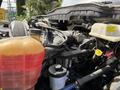 Close-up view of the engine compartment of a 2011 International 4300 featuring various hoses and components including a coolant reservoir and an oil filter