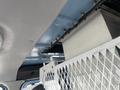 Interior view of a 2010 Ford Econoline showing a metal partition and the vehicle's ceiling structure