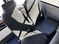 Two black leather seats with seatbelts in a vehicle