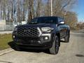 A 2021 Toyota Tacoma with a black exterior and a distinctive hexagonal grille parked on a street