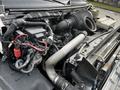 Close-up view of the engine compartment of a 2006 GMC C5000 featuring various hoses wires and components including an air intake and battery connections