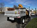 A 2013 International DuraStar 4300 truck with a flatbed and a yellow crane attached at the rear