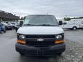 A white 2014 Chevrolet Express van with a black front grille and headlights visible from the front angle