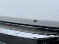 A white 2016 Ford F-150 with a small paint chip on the hood and water droplets on the surface
