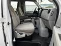 Interior of a 2011 Ford Econoline showing two front seats and a center console with cup holders