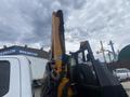 A 2017 Ford F-550 with a yellow hydraulic crane attachment in the upright position