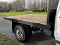 A 2017 GMC Sierra 3500HD with a wooden flatbed and shiny silver wheels