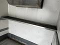 A metal shelf inside a cargo area, featuring a smooth surface and mounted along a wall with a silver metal edge