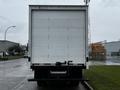 A white 2021 Mitsubishi FE box truck facing away with a plain rear door and no visible markings